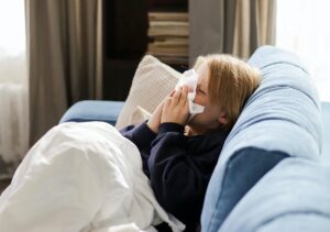 Bolan otrok na kavču, smrka v robček